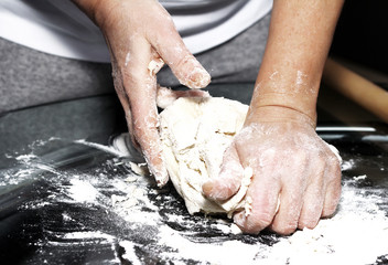 Making dough by female hands on glass table background