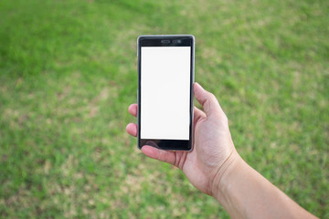 Right hand holds mobile phone in park