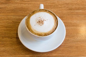 hot cappuccino on vintage wood desk background