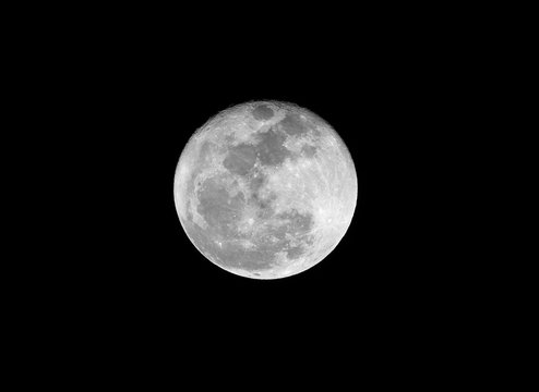 .Full moon over dark black sky on night