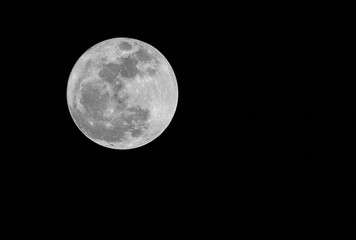 Full moon over dark black sky at night.