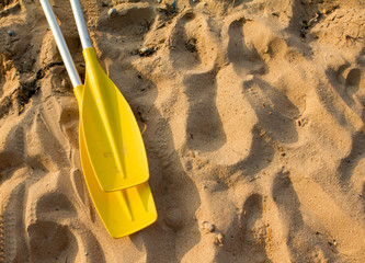 Two Yellow paddle on the beach when sunset