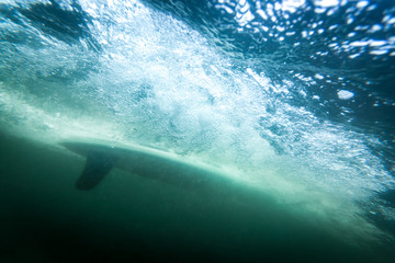 surfboard underwater with fin and air bubbles
