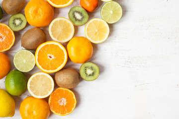 Fruits reach in vitamin C: oranges, lemons, limes, clementines, kiwis, top view, selective focus