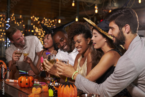 Friends enjoying a Halloween party at a bar making a toast