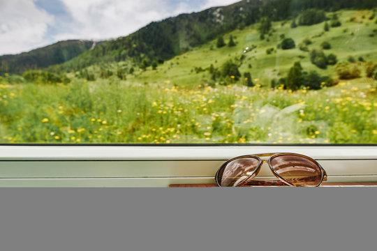 Sunglasses and smartphone by passenger train window, Chur, Switzerland