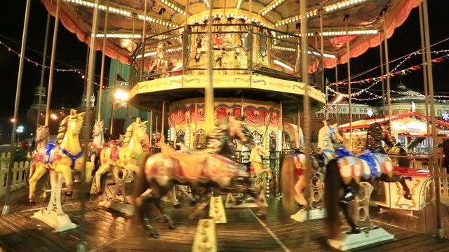  Festive merry-go-round whirling and sparkling lights near Upper Trading Rows
