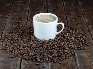 Coffee mug with grains on dark wood background