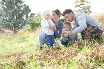 Fototapeta premium Family looking at flowers in countryside