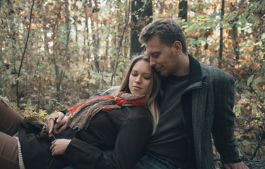 Loving couple resting in autumn forest