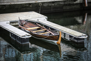 Altes Fischerboot aus Holz im Wasser an einem Steg
