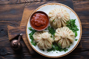 Above view of khinkali dumplings with coriander and satsebeli