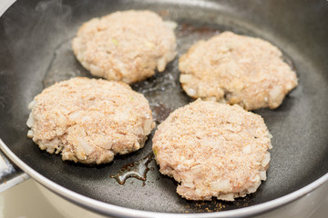 Frying meatballs of minced meat with onions in the frying pan