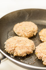 Frying meatballs of minced meat with onions in the frying pan