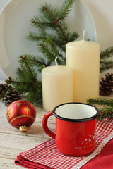 Pentolino sul tavolo con candele e oggetti natalizi