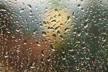 Rain drops on window with house and church in background
