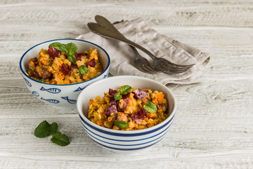 lentil with sausage and vegetables in pot on rustic background, top view