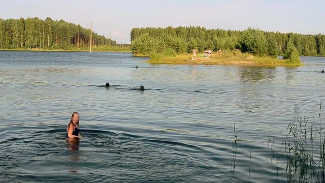 People swimming in lake at green forest in summer sunny day. Nature. Girl dive underwater. Recreation. Rest