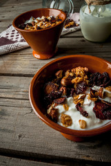 The cozy breakfast, homemade granola with dried fruits and nuts and organic yogurt. Rustic wooden table