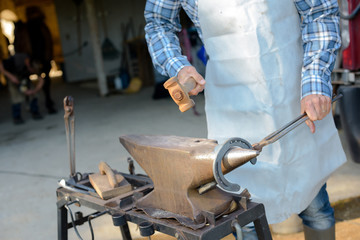 Farrier making horseshoe