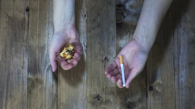 rotten apple and cigarette in the hands.