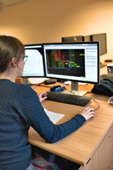 Young woman working in office on computer. Female architect in g