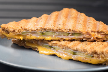 Pile of grilled sandwiches with cheese and ham.