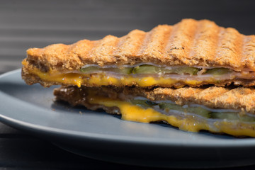 Pile of grilled sandwiches with cheese and ham.