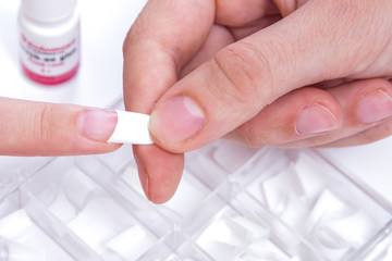 Manicure. Master make nail extension. Finger closeup isolated on white background. 
