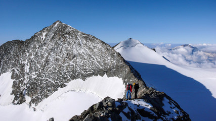 a mountain guide and client an an exposed rocky ridge in the Swiss Alps near Pontresina
