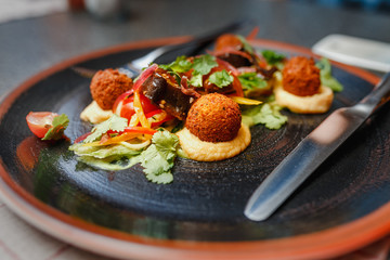 delicious falafel dish with veggies and sauce in restaurant background