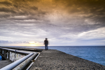 Walking on a pier toward the sunrise