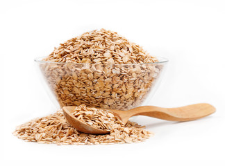 Healthy food. Oat flakes in glass bowl and spoon on white background. Close up, high resolution...