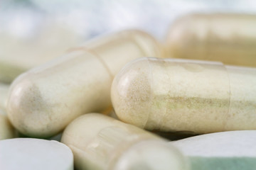 Natural food supplement pills, glucosamine capsules and calcium, macro image, soft blurred background.