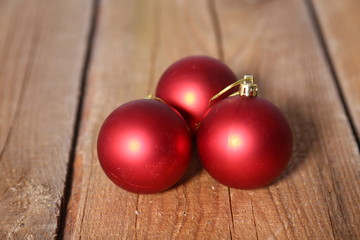 Three red Christmas Balls over wooden background