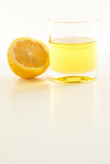 lemon and a glass of lemonade on a white background