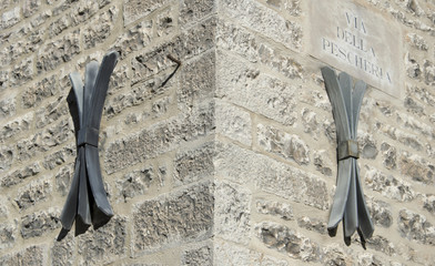 Facade of an old italian masonry building with metal tie-rod and anchor plate.