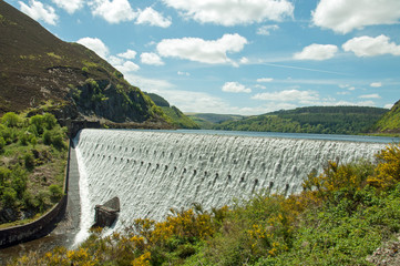 Elan valley and the Rhayader dams of Powys, Wales.

A summertime scene of water flowing over the...