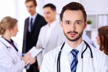 Fototapeta premium Friendly bearded male doctor with patients