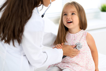 Doctor examining a little girl by stethoscope
