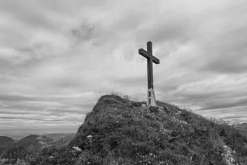 Tuinposter Black and white image of a cross on hillside in the Swiss alps © Mivr