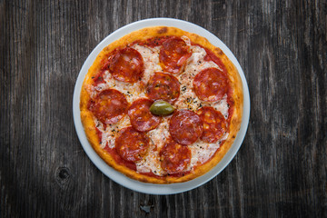 Pizza margarita with cheese and tomato isolated on rustic wooden table