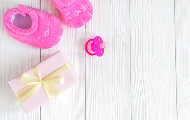 baby's bootees and gift box on wooden background