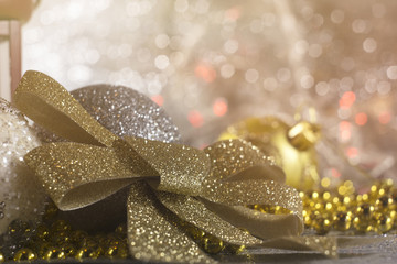 Christmas bow and ornaments on shiny background