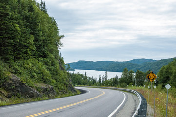 curved road with large lake and mountains in distance