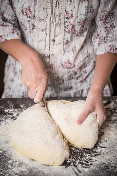 Close up of hands cutting dough