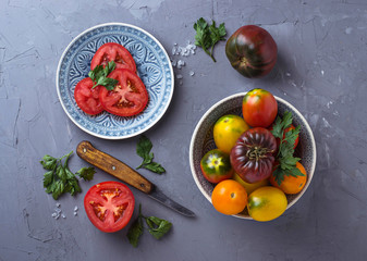 Tomato, salt, parsley and knife on gray concrete background