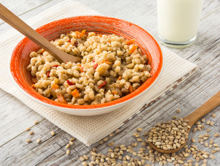 Pearl barley porridge with vegetables in a ceramic dish