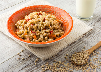 Pearl barley porridge with vegetables in a ceramic dish