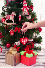 Decorating Christmas tree on bright background